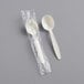 A wrapped beige plastic soup spoon.