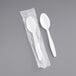 A white plastic spoon in plastic packaging.