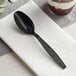 A black Choice plastic teaspoon on a napkin.