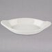 A white oval Hall China rarebit dish on a gray surface.