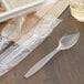 A plastic container of plastic-wrapped Choice Clear Heavy Weight Teaspoons.