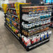 Wanzl double-sided gondola shelving with snacks on the shelves in a store.