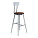 A National Public Seating Titan lab stool with a steel frame and Montana Walnut wood seat and backrest.