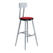 A National Public Seating gray and hollyberry lab stool with a metal frame and red seat.
