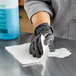 A person cleaning a surface with a white cloth.