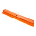 A close-up of a Carlisle Sparta orange push broom head.