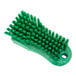 A close-up of a Carlisle Sparta green handheld scrub brush with bristles.