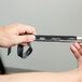 A hand holding a black Unger ErgoTec squeegee blade.