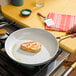 A piece of Eat Meati plant-based cutlet cooking in a pan.