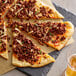 A plate of pizza with Abbot's Butcher plant-based Italian sausage crumbles and cheese.