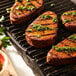 A piece of Eat Meati Plant-Based Carne Asada Steak on a grill with green sauce.