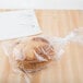 A loaf of bread in a plastic bag on a counter.