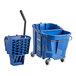 A blue plastic Carlisle OmniFit mop bucket with wheels and a handle.