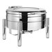 An Eastern Tabletop stainless steel round chafer with a glass lid on a stand.