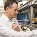 A man wearing a white shirt uses a Midland BizTalk walkie talkie.