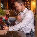 A man wearing earphones uses a Midland BizTalk BR180 walkie talkie on a bar's touch screen.