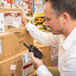 A man holding a Midland BizTalk On-Site Business Radio BR180 near stacked cardboard boxes.