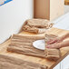 A woman using ecoMAX Care cellulose wadding to pack a plate on a table.