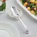 An Acopa Skyscraper stainless steel serving spoon on a white plate.