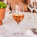 A Chef & Sommelier wine glass filled with wine on a table.