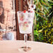 An Arcoroc Monti cocktail glass filled with fruit juice, ice, and fruit.
