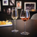 Two Chef & Sommelier Distinction flute glasses of white wine on a table.