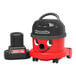 A red and black NaceCare cordless canister vacuum with a black plastic container and wheels.