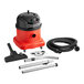 A red and black NaceCare Solutions canister vacuum with hose and accessories.