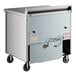A large metal True worktop refrigerator with wheels.