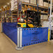 A man driving a ZonePro dual rolling stanchion with blue safety banners.