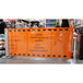 A person rolling a ZonePro Dual Rolling Stanchion with orange safety banners.