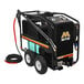 A Mi-T-M electric hot water pressure washer with a hose and wheels.