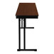 A National Public Seating rectangular wood folding table with a brown top and black frame.