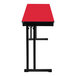 A red rectangular National Public Seating folding table with black T-mold border and black cantilever legs.