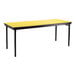 A yellow rectangular National Public Seating plywood folding table with black legs and a black T-mold edge.