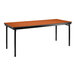 A National Public Seating rectangular folding table with black legs and a wild cherry top with T-mold edge.