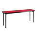 A red table with black legs and a black T-molded top.