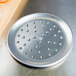 An American Metalcraft aluminum pizza pan with holes.