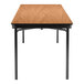 A National Public Seating rectangular Bannister Oak plywood folding table with black T-mold edge and black legs.