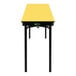 A yellow rectangular table with a black border and black legs.