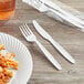 A plastic wrapped pack of white heavy weight Choice plastic cutlery with a fork and knife.