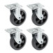 A group of Lancaster Table & Seating black rubber swivel casters with steel plates.