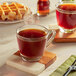 Two Lavazza Gran Selezione K-Cup pods on a table with a glass of brown liquid and a waffle.