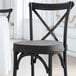 A close up of a Lancaster Table & Seating black chair cushion with ties.