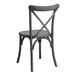 A Lancaster Table & Seating black metal outdoor chair with a cross back.