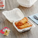 A white Choice plastic take-out container with food inside.