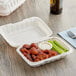 A white Choice take-out container with wings and celery sticks inside.