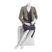 A white Econoco female seated mannequin with hands on lap wearing a dress and jacket.