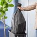 A person holding a Lavex black trash bag