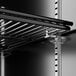 A metal shelf inside a black refrigerated glass door.